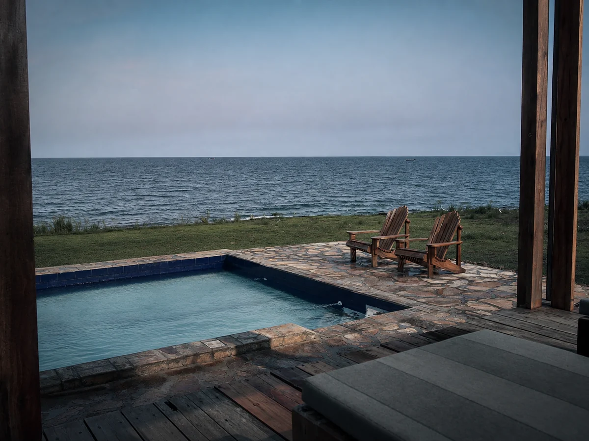 Infinity pool and lounge chairs facing the lake at dusk at Walindi Point.